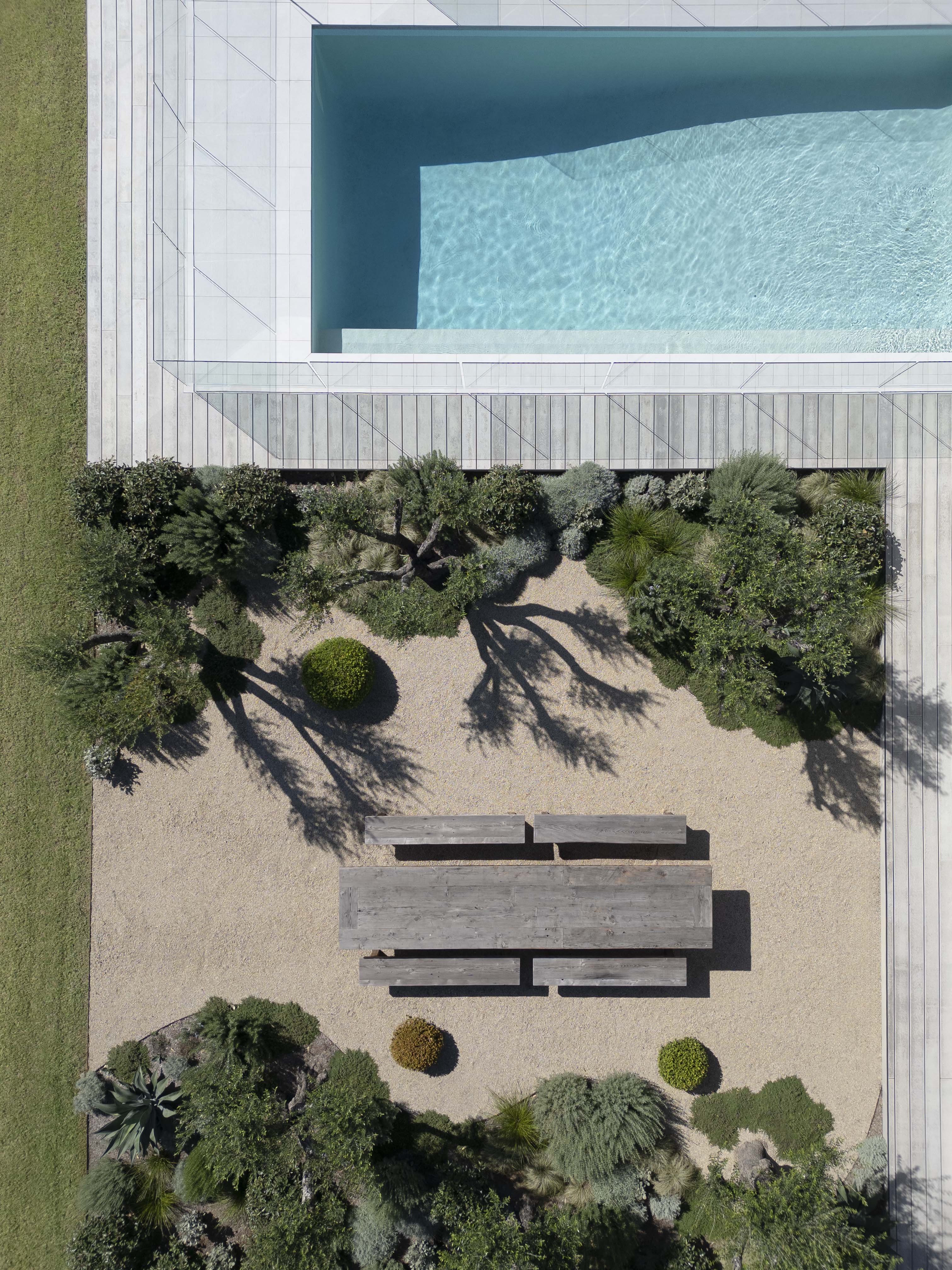 Whispering fig 12 Aerial view of rectangular pool, timber deck and gravel garden with outdoor dining table and olive trees